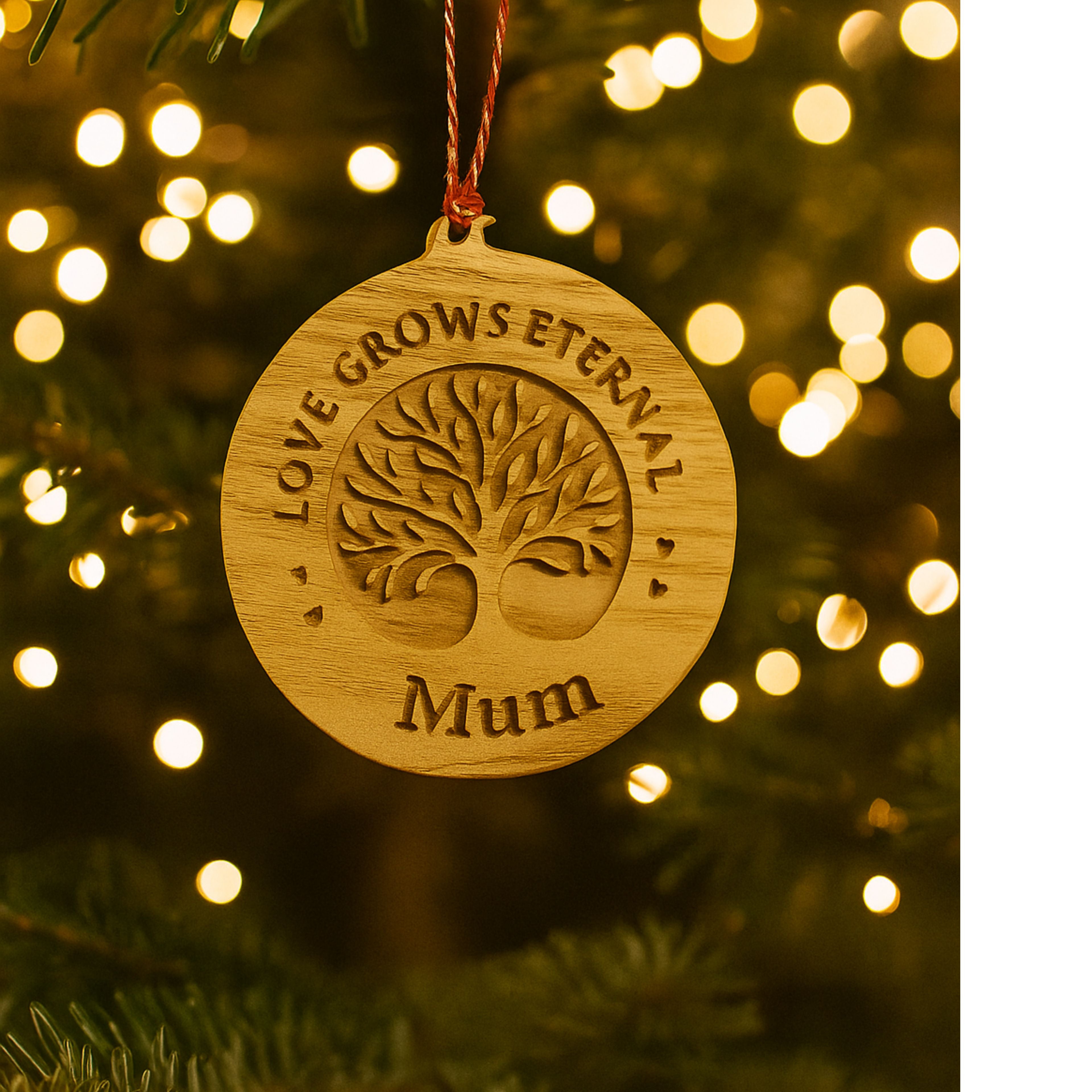 Wooden ornament with 'Love Grows Eternal Mum' text on a Christmas tree with lights.