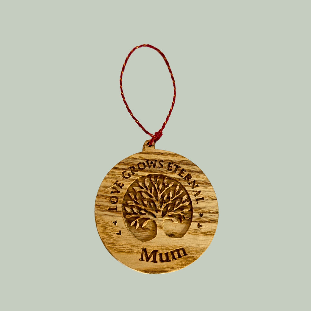 Wooden ornament with 'Love Grows Eternally Mum' text on a light gray background