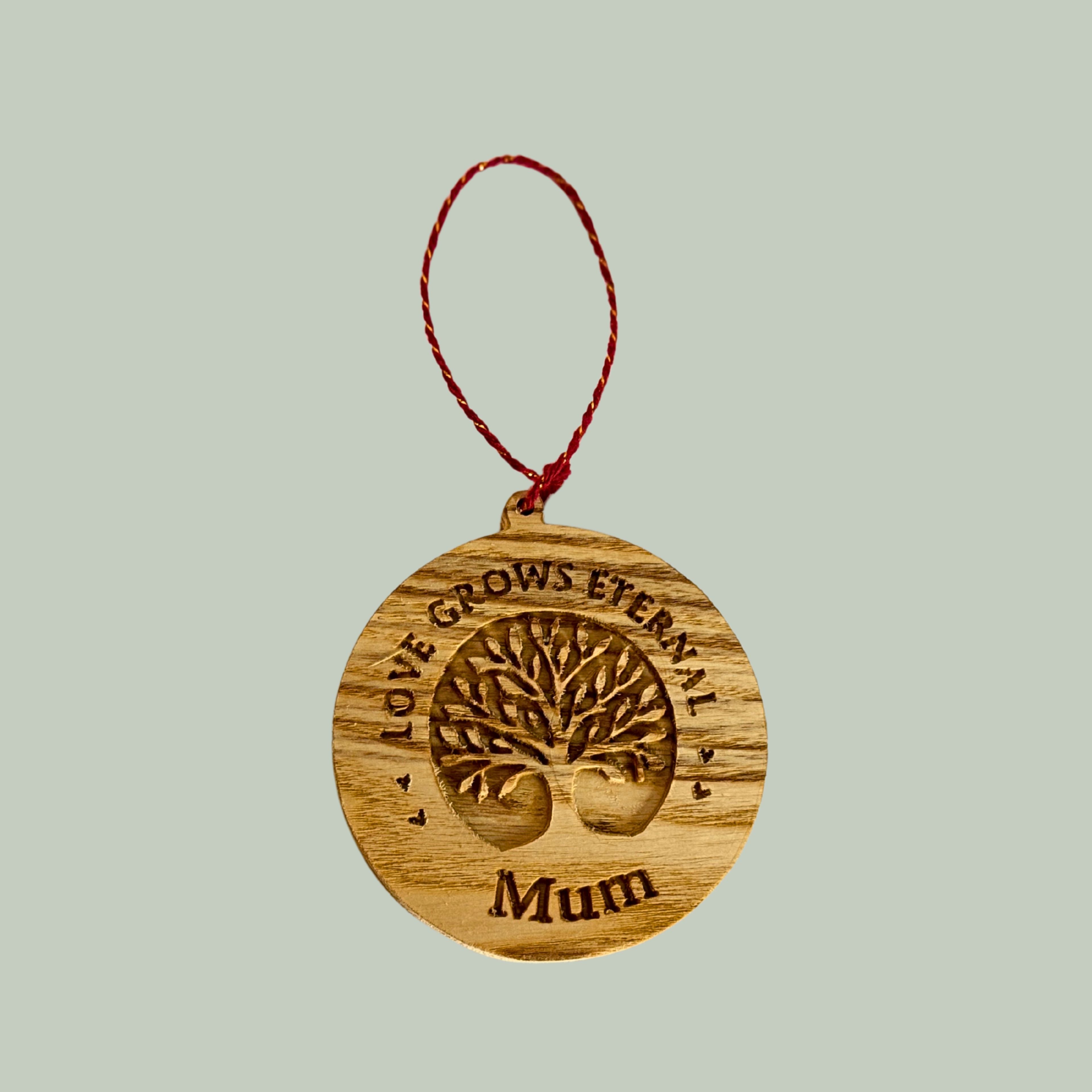 Wooden ornament with 'Love Grows Eternally Mum' text on a light gray background