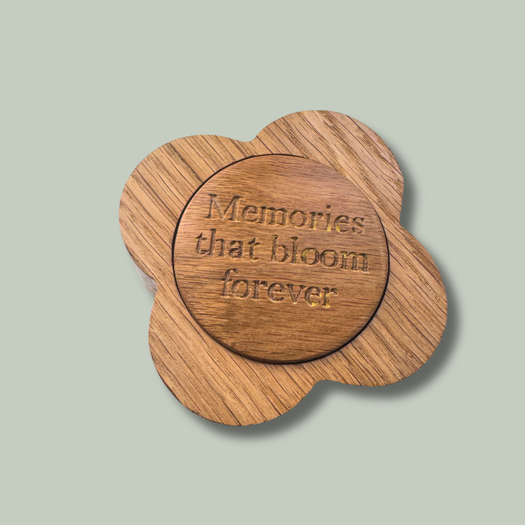 Wooden trinket box with 'Memories that bloom forever' text on a light gray background.  Top view